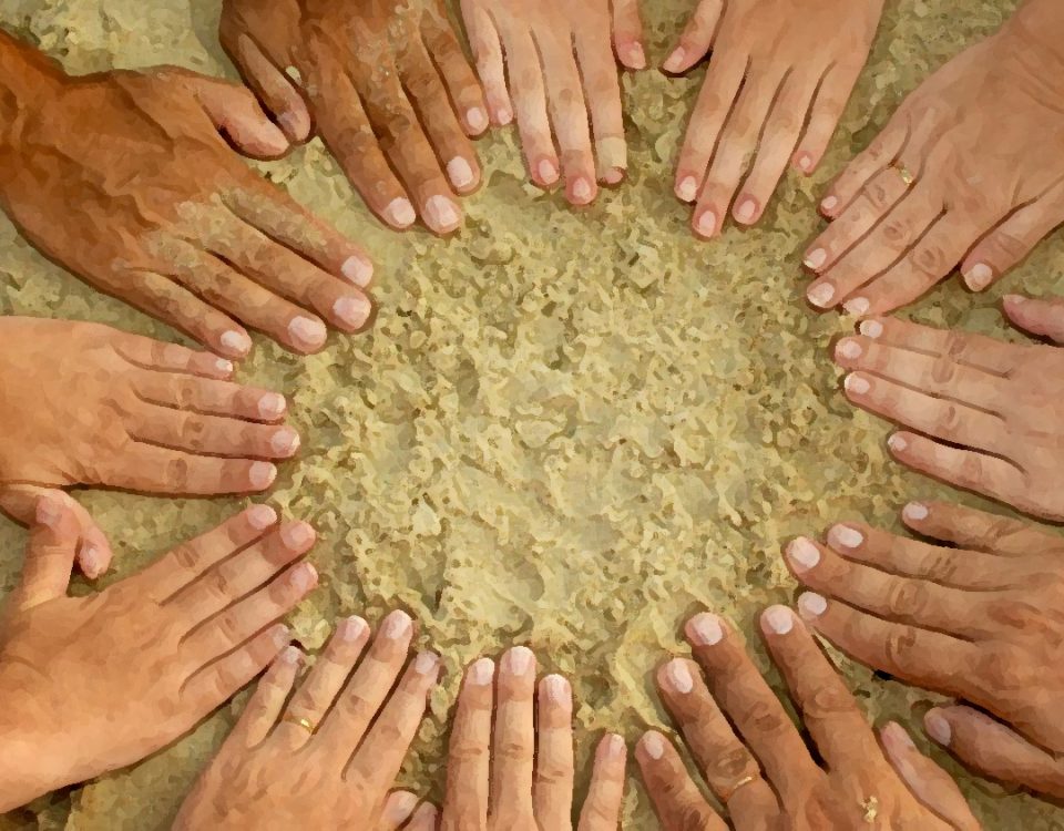 Photo of a circle of hands in the sand